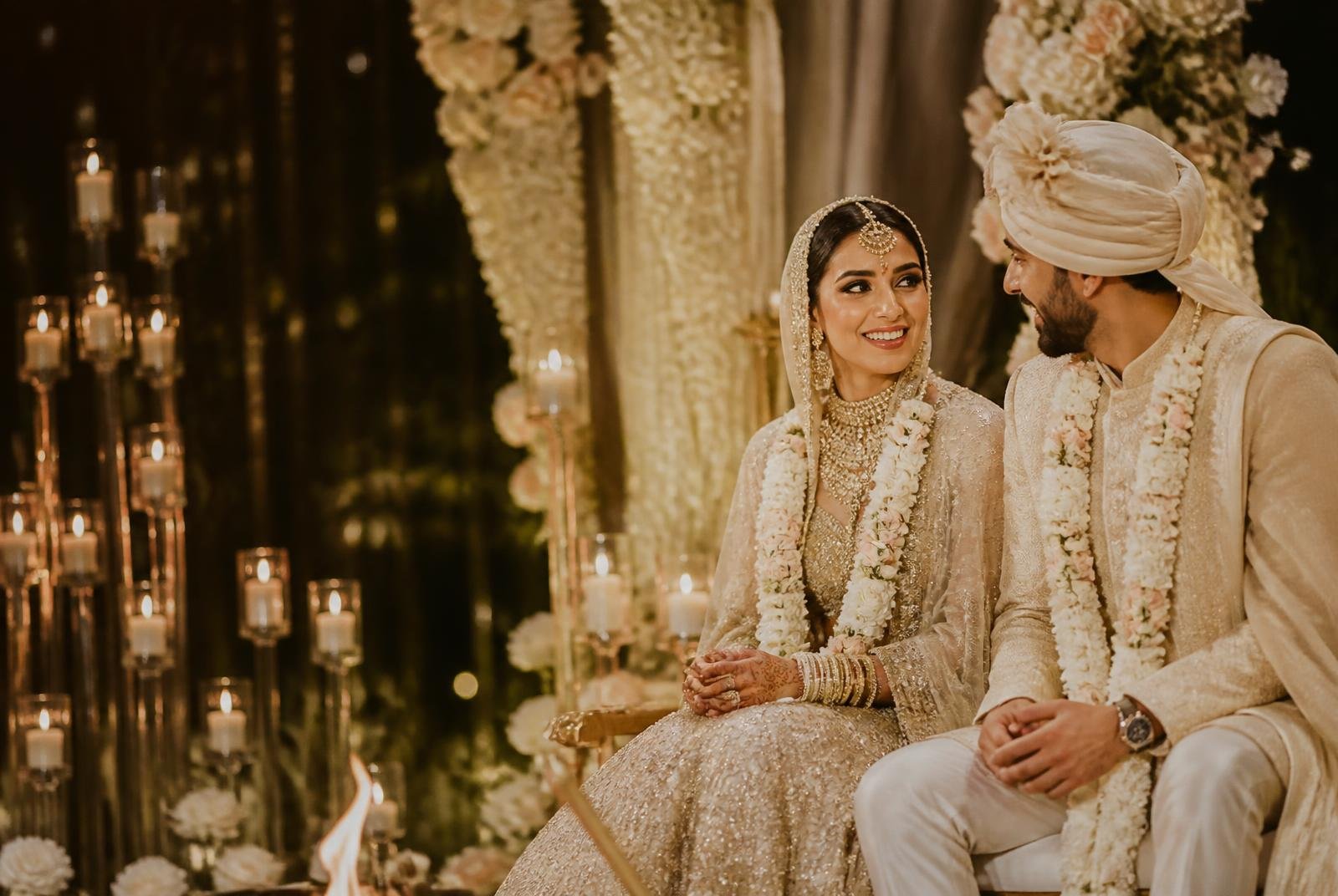 Bride and groom seated together during a candlelit wedding ceremony