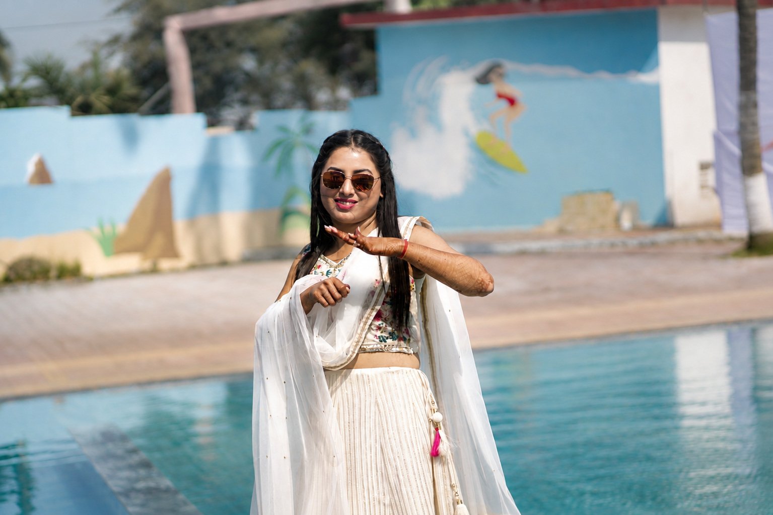 Bride dancing poolside in ivory as the destination celebration begins