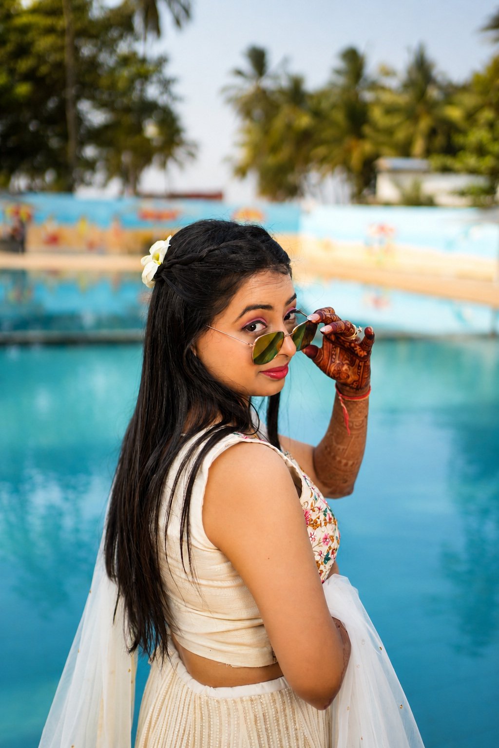 Bridal portrait beside the resort pool with a flower tucked into her hair