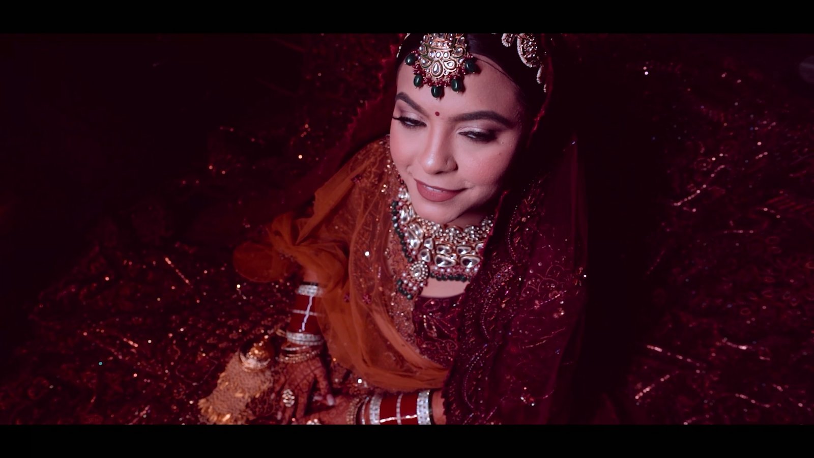 Bridal portrait of Moni in red, lit by warm candlelight
