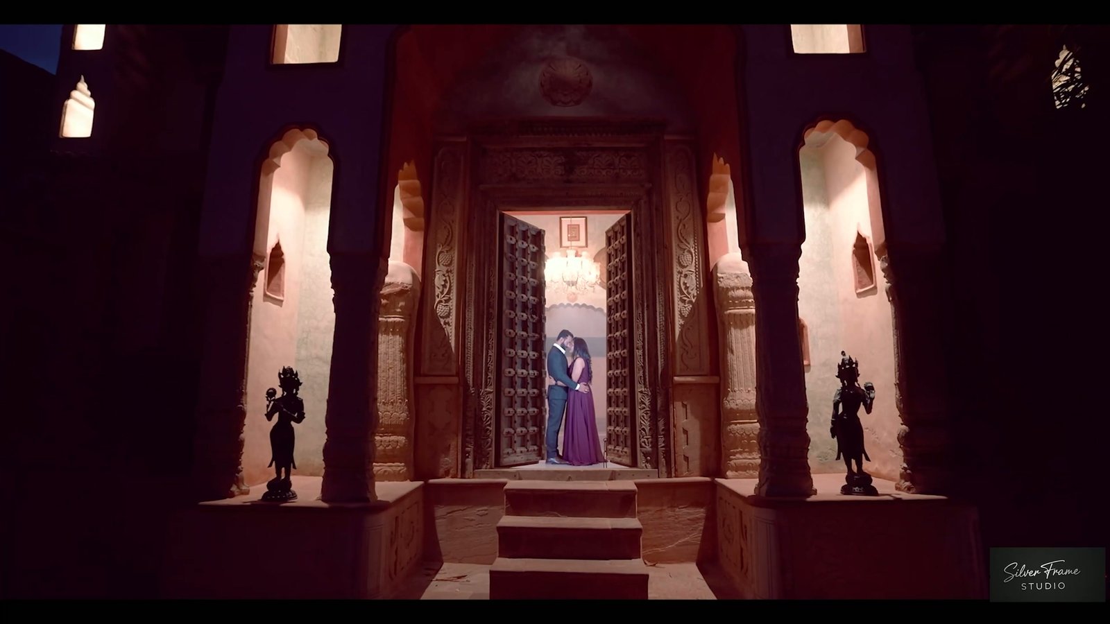 Sachidanand and Pooja framed in a lantern-lit heritage doorway