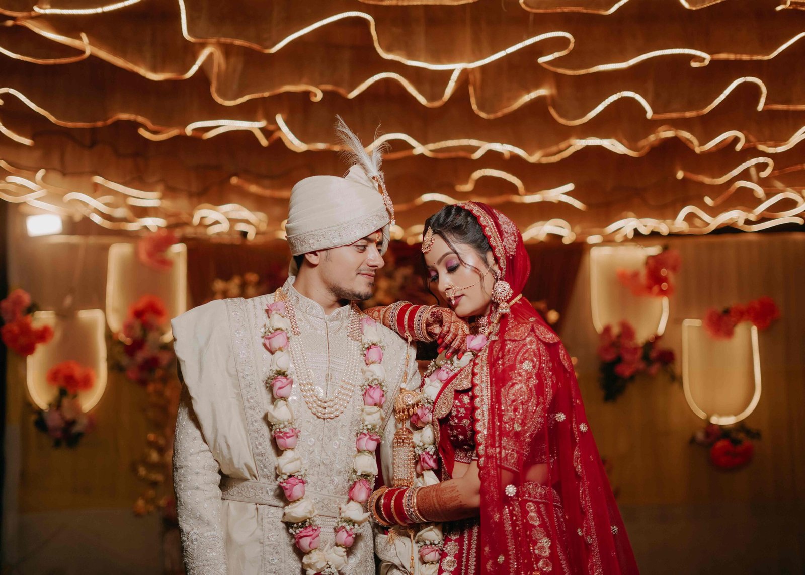 Bride and groom together beneath a canopy of warm fairy lights